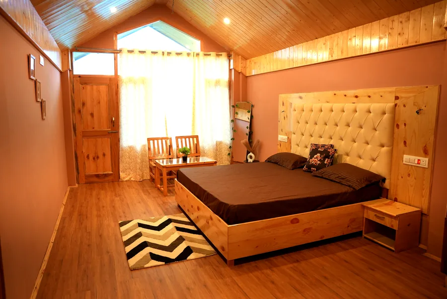 Attic bedroom with cream tufted headboard and wooden ceiling