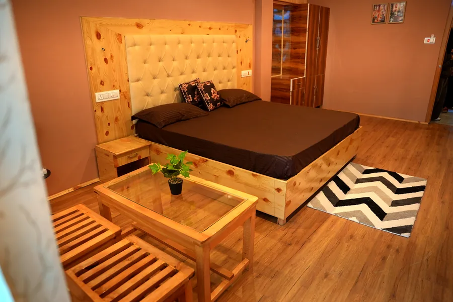Bedroom with wooden bed, coffee table and warm light
