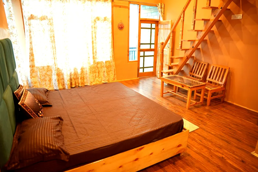 Duplex room with wooden staircase and double bed