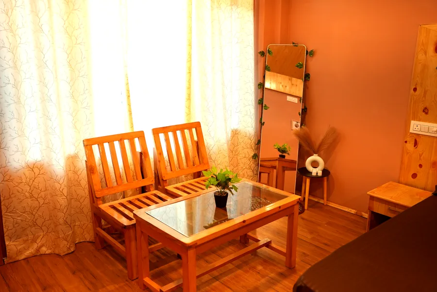 Cosy sitting area with wooden chairs and floor mirror