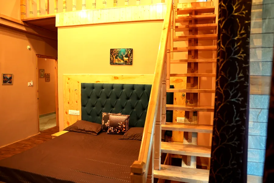Attic room with teal headboard and ladder staircase