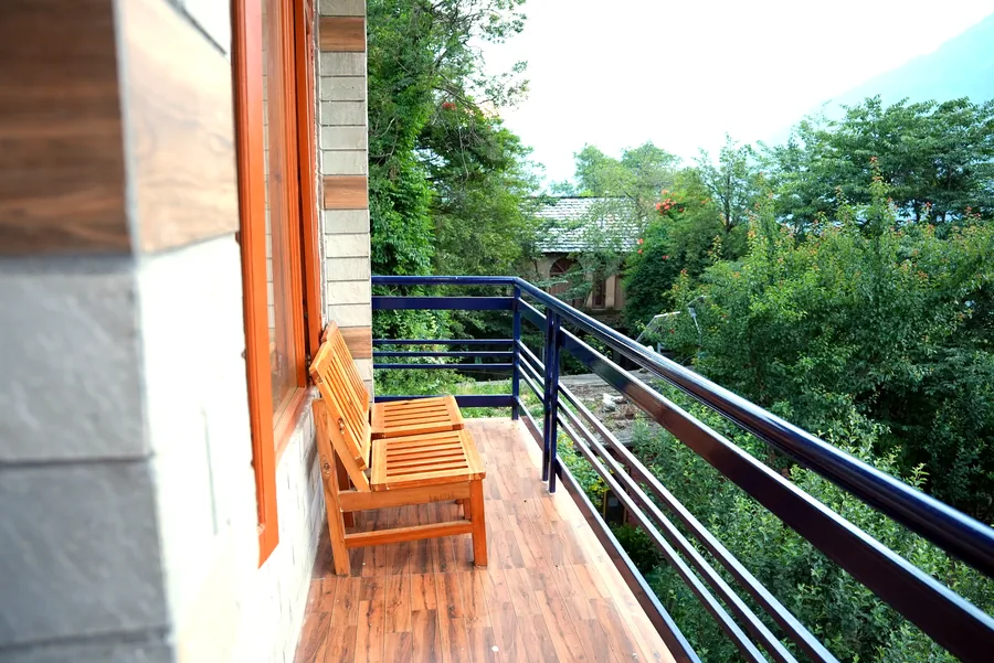 Wooden bench on balcony overlooking lush green trees