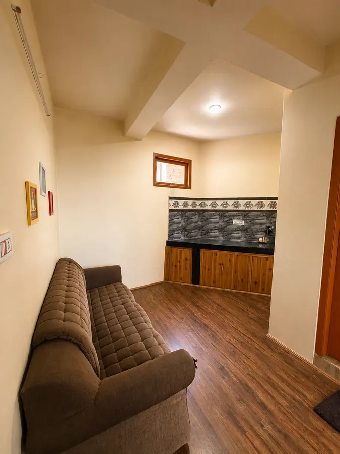 Homestay room in Naggar with wooden bed and warm interiors